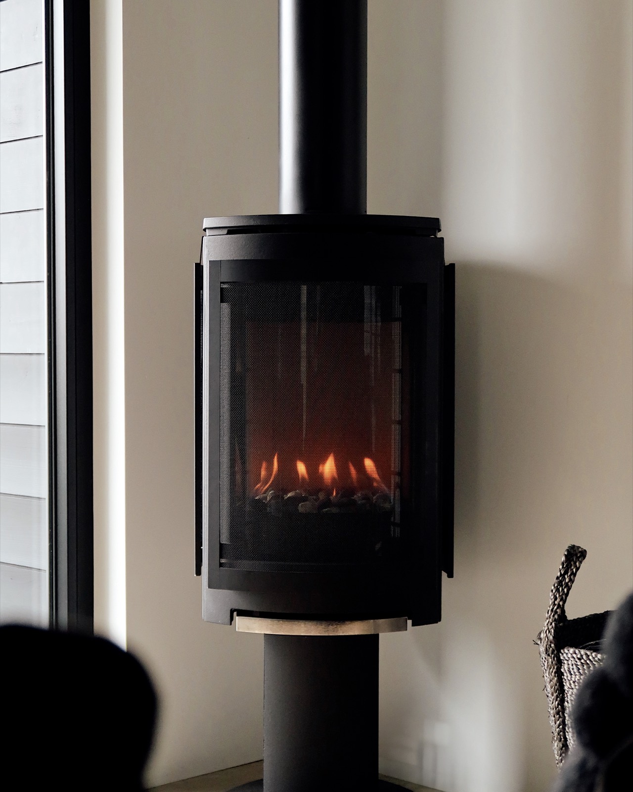 The wood stove lit, warm against the minimalist interior