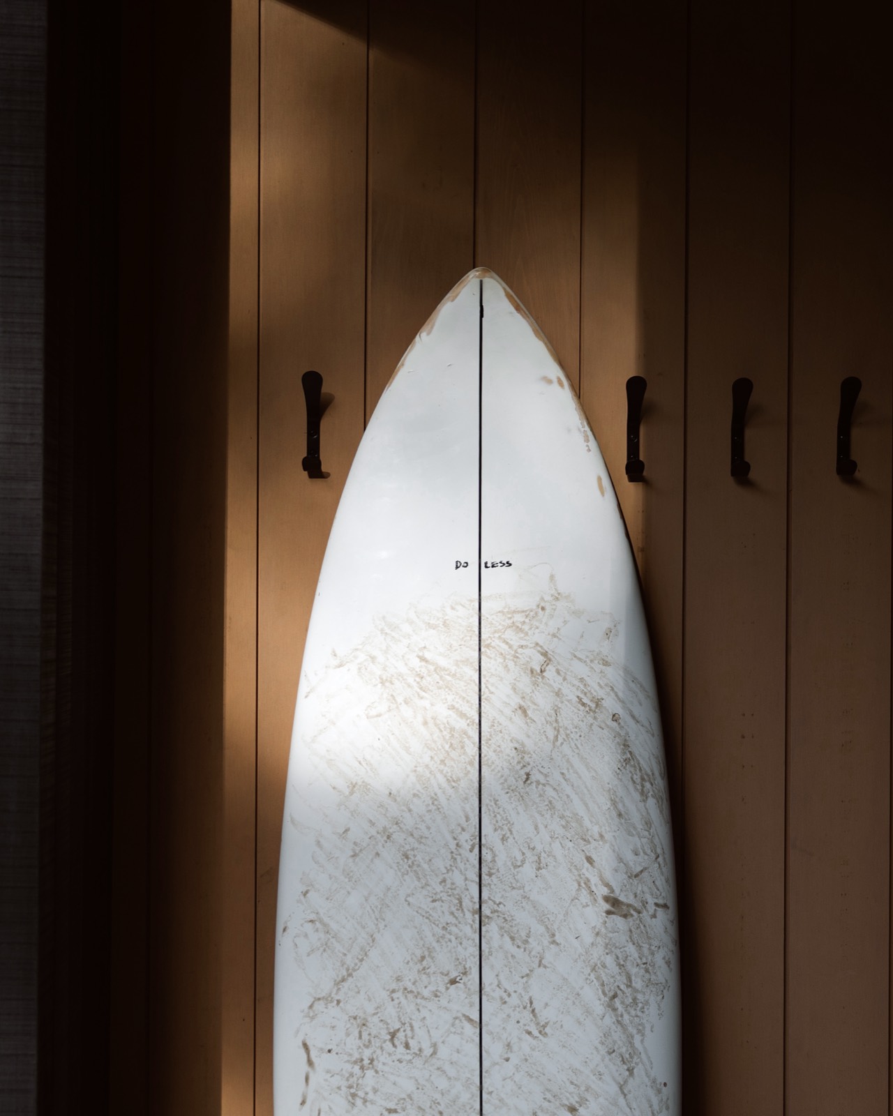 A surfboard leaning against the warm wood-panelled interior