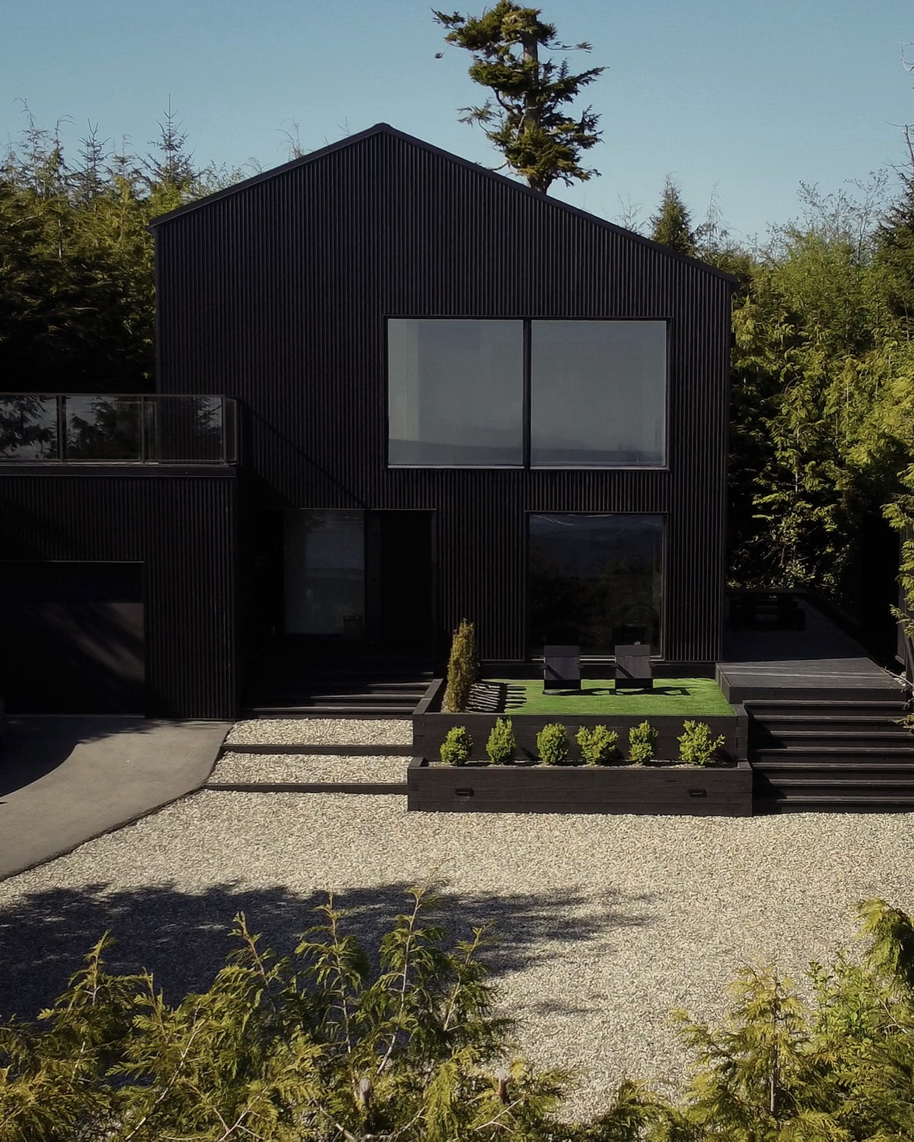 The Black Shack — the black-clad home set into the coastal forest