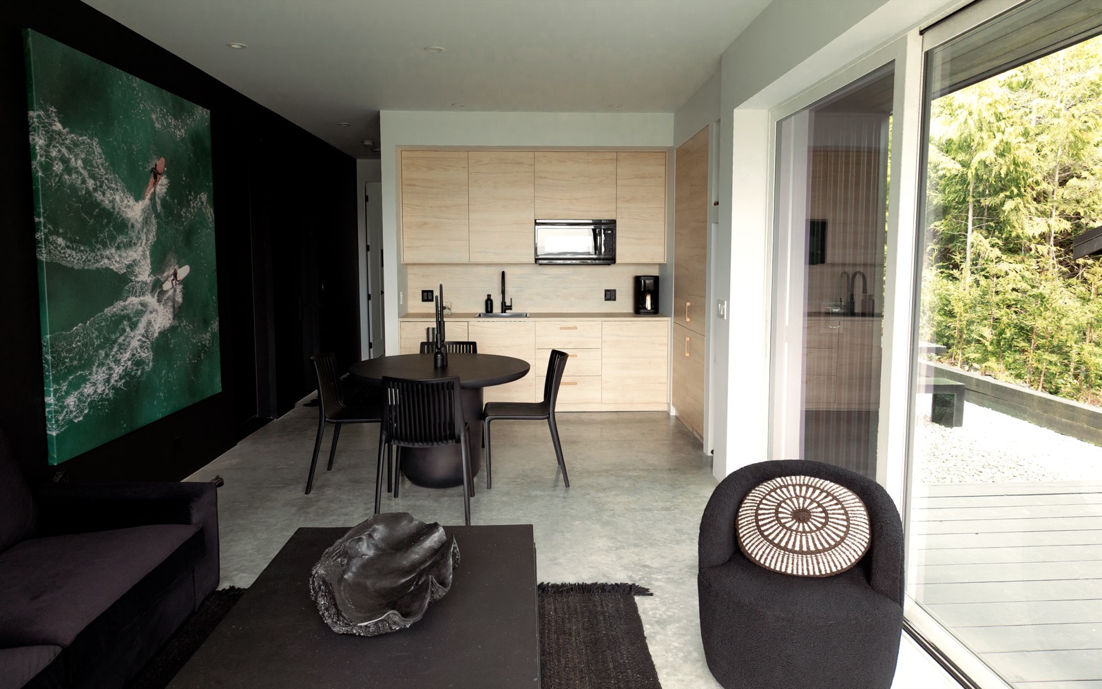 Living space with a deep-green ocean artwork and dark minimalist interior